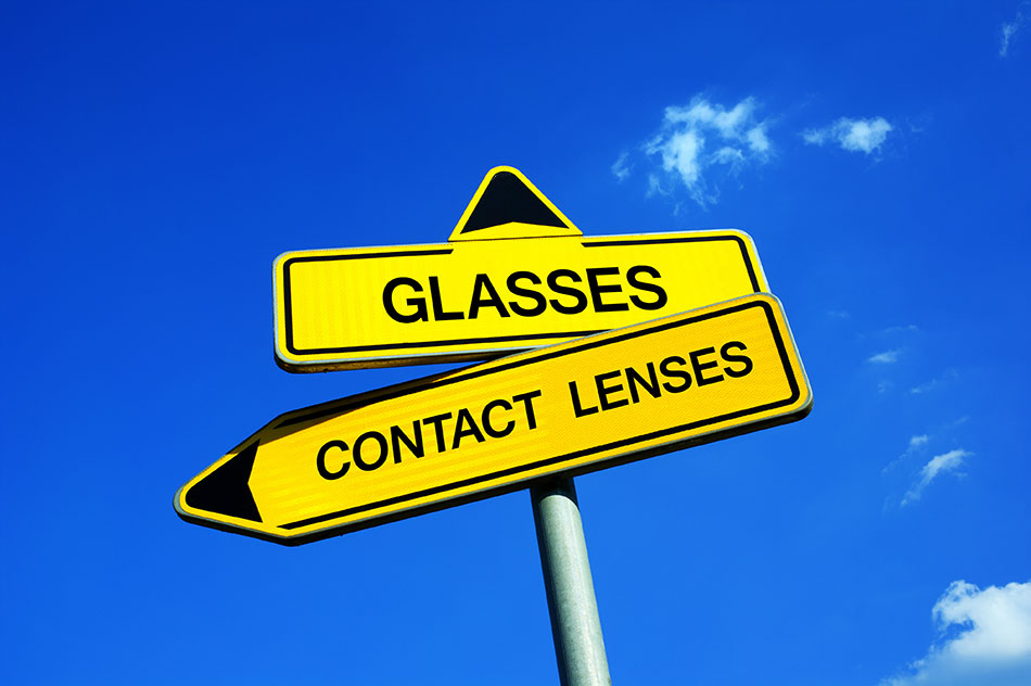 contact lenses vs glasses signpost on sky background