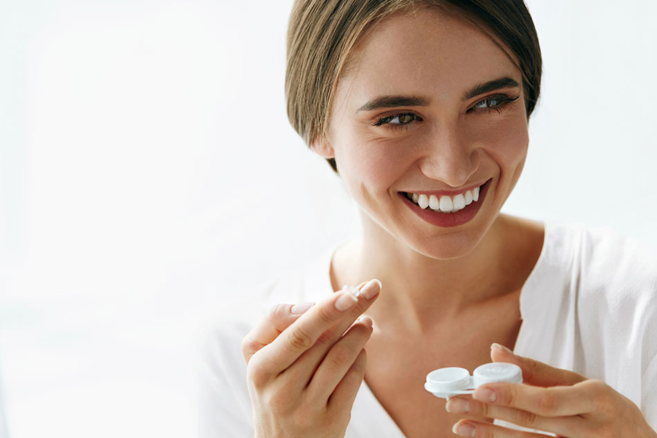 happy woman holding contacts in hand