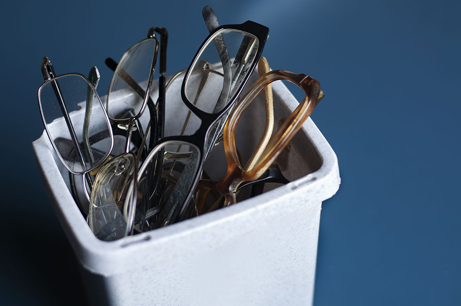 Old reading glasses in trash bin