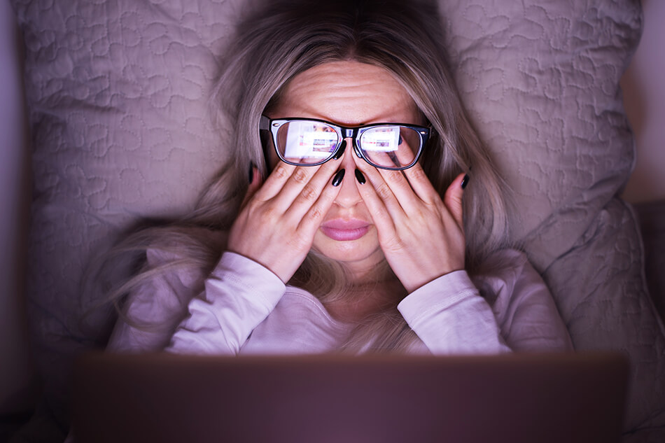 woman with eye strain in front of computer