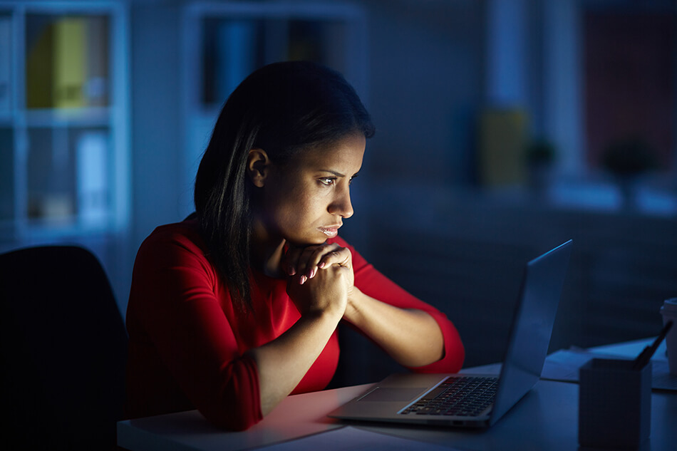 woman working on laptop computer  in dark office