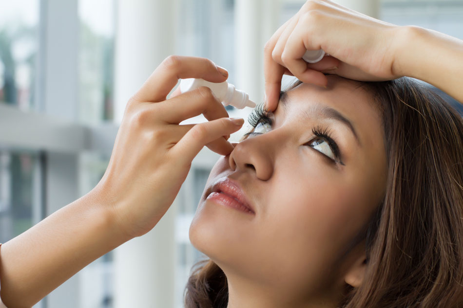 young woman putting in eye drops